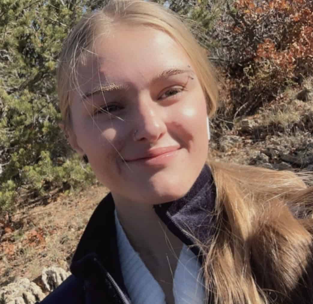 Selfie of Kadence Presser in front of pine trees.